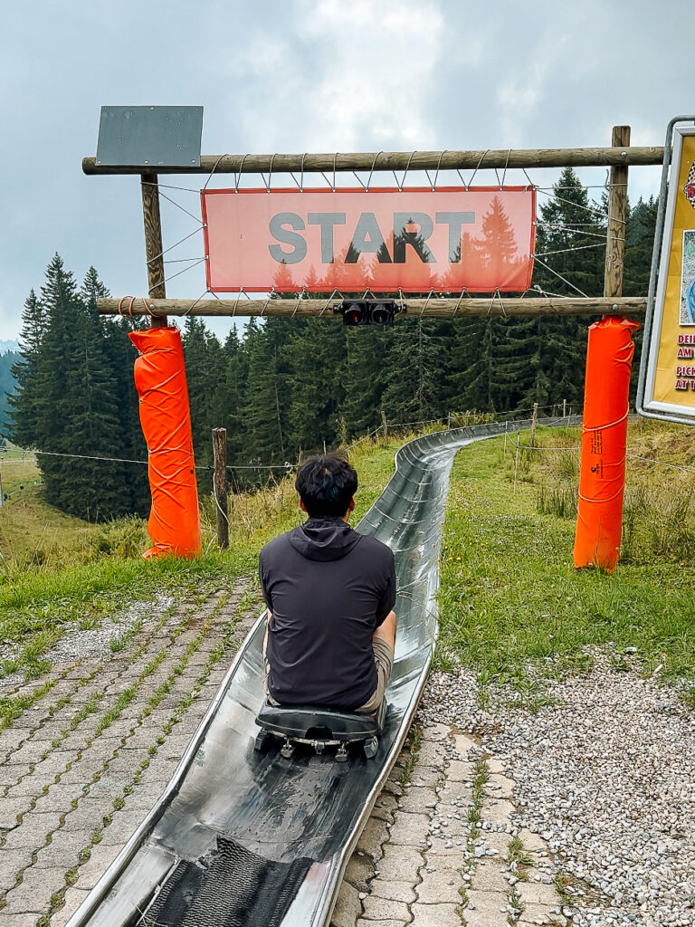 A person seated on a toboggan at the start of the summer slide at Mount Pilatus.